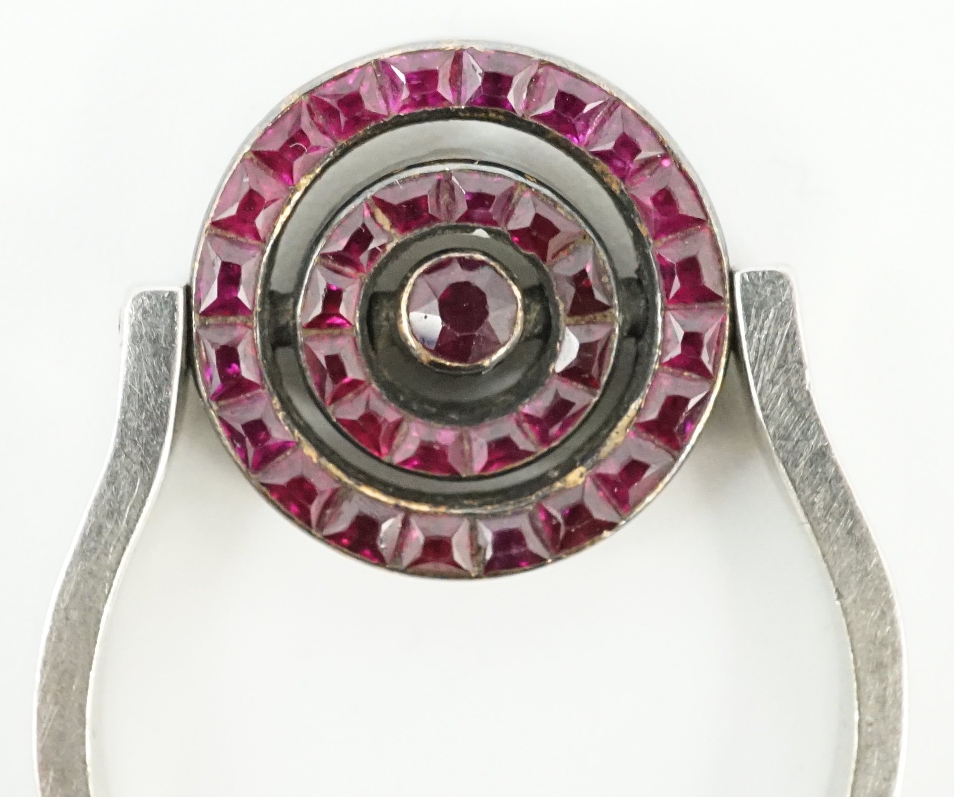 A platinum?, ruby and diamond cluster set swivelling target ring